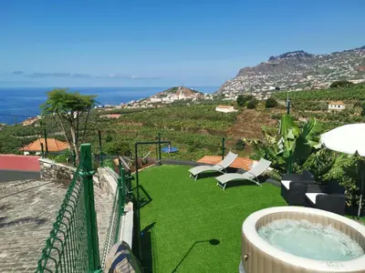 a hot tub on a balcony with a view of the ocean at Villa Nova Madeira in Funchal Casa A and B in Funchal