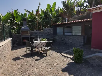 a patio with a table and chairs in front of a house at Villa Nova Madeira in Funchal Casa A and B in Funchal