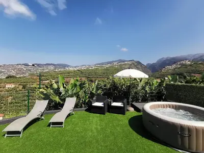 a hot tub and chairs on a lawn with a view at Villa Nova Madeira in Funchal Casa A and B in Funchal
