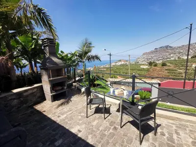 a patio with a fireplace and a table and chairs at Villa Nova Madeira in Funchal Casa A and B in Funchal
