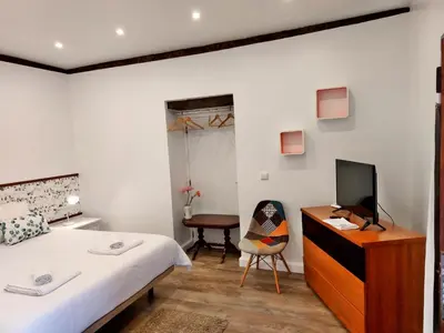 a bedroom with a bed and a desk and a chair at Villa Nova Madeira in Funchal Casa A and B in Funchal