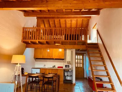 a kitchen with a wooden staircase in a house at Casinha da Praia in Carrapateira