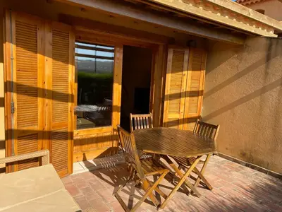 a wooden table and chairs on the porch of a house at Casinha da Praia in Carrapateira