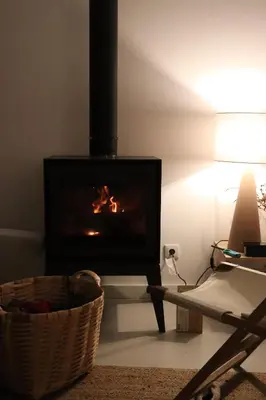 a living room with a fireplace and a chair at New! Casa do Mar - Pedralva - Sagres- Surf & Nature in Vila do Bispo