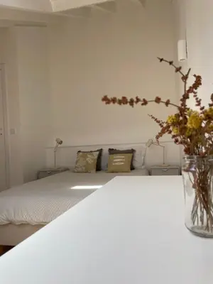 a bedroom with a bed with a vase of flowers at New! Casa do Mar - Pedralva - Sagres- Surf & Nature in Vila do Bispo