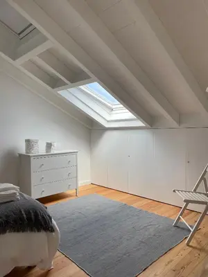 a bedroom with a bed and a chair and a skylight at New! Casa do Mar - Pedralva - Sagres- Surf & Nature in Vila do Bispo