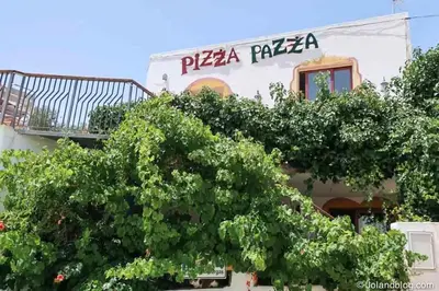 a tree in front of a building with a pizza pizza sign at New! Casa do Mar - Pedralva - Sagres- Surf & Nature in Vila do Bispo