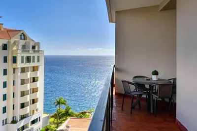 a balcony with a table and a view of the ocean at Blue View, a Home in Madeira in Funchal