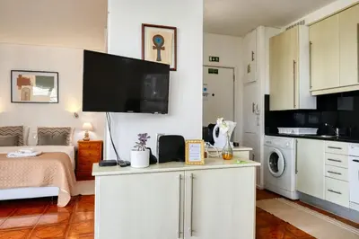 a small room with a bed and a tv on the wall at Blue View, a Home in Madeira in Funchal