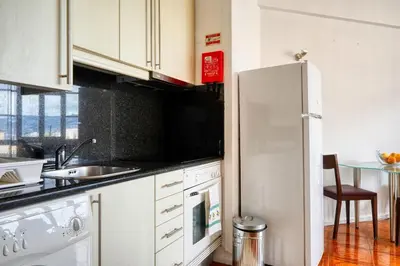 a white kitchen with a sink and a refrigerator at Blue View, a Home in Madeira in Funchal