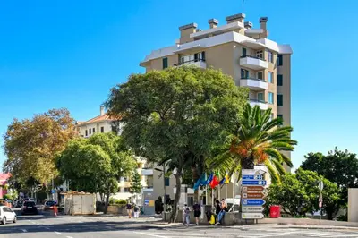 a tall white building on a city street with trees at Blue View, a Home in Madeira in Funchal
