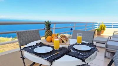 a table with food and orange juice on a balcony at The Atlantic Lookout by LovelyStay in Caniço