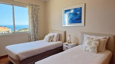 two beds in a room with a window at The Atlantic Lookout by LovelyStay in Caniço