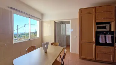 a kitchen with a wooden table and a window at The Atlantic Lookout by LovelyStay in Caniço