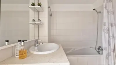a white bathroom with a sink and a shower at The Atlantic Lookout by LovelyStay in Caniço