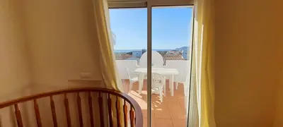 a room with a balcony with a view of a table at Apartamento Pedras Pretas in Porto Santo