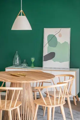 a table and chairs in a room with a green wall at Lido I by An Island Apart in Funchal
