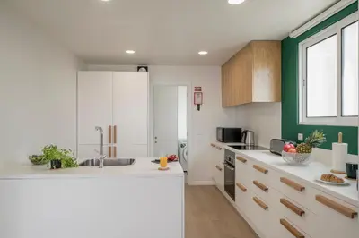 a kitchen with white counters and a green wall at Lido I by An Island Apart in Funchal