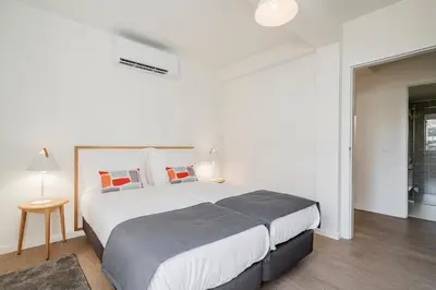 a white bedroom with a large bed with pillows at Lido I by An Island Apart in Funchal