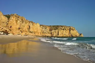 a sandy beach with a rocky shore and the ocean at BUGANVÍLEA - Vivenda johanna in Lagos