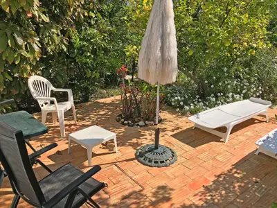 a patio with chairs and a table and an umbrella at BUGANVÍLEA - Vivenda johanna in Lagos