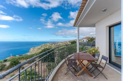 a balcony with a table and chairs and the ocean at Ocean View Tabua by Holiday Rental Madeira in Ribeira Brava