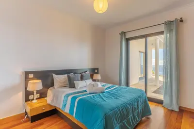 a bedroom with a bed and a large window at Ocean View Tabua by Holiday Rental Madeira in Ribeira Brava
