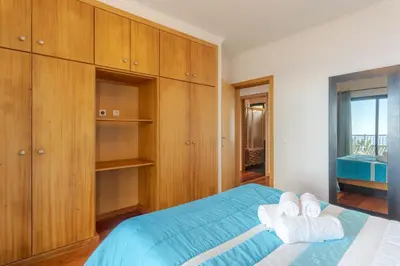 a bedroom with wooden cabinets and towels on a bed at Ocean View Tabua by Holiday Rental Madeira in Ribeira Brava