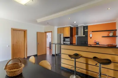 a kitchen with a black table and some chairs at Ocean View Tabua by Holiday Rental Madeira in Ribeira Brava