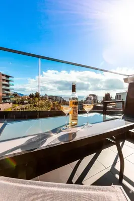 two glasses of wine sitting on a table on a balcony at Banana Lodge by Atlantic Holiday in Funchal