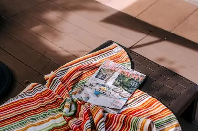 a magazine sitting on top of a blanket on a bed at La Madérene with Pool by Stay Madeira Island in Tábua