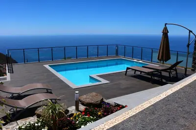 a swimming pool with a view of the ocean at Casa da Caixeira in Arco da Calheta