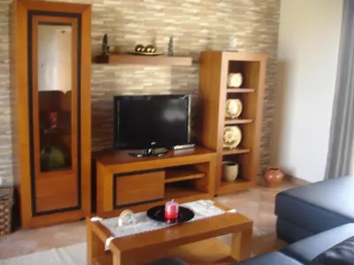 a living room with a tv and a table at Casa da Caixeira in Arco da Calheta