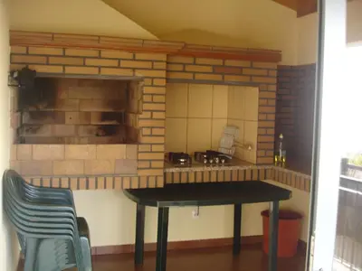 a kitchen with a table and a brick wall at Casa da Caixeira in Arco da Calheta
