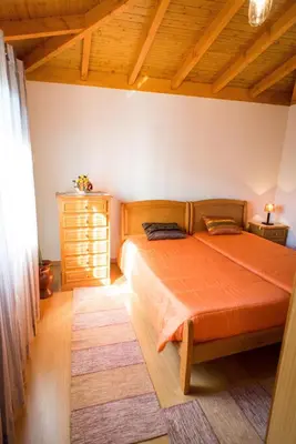 a bedroom with a bed with an orange bedspread at Casa da Caixeira in Arco da Calheta