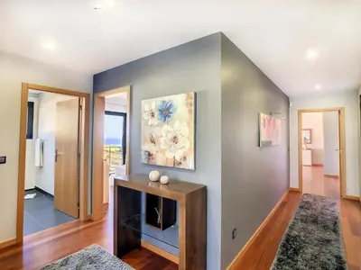 a living room with a fireplace and a gray wall at Villa Serramar in Estreito da Calheta
