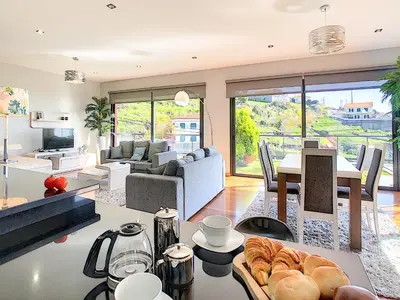 a large living room with a table and a living room at Villa Serramar in Estreito da Calheta