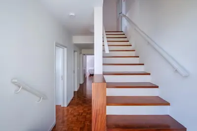 a staircase in a house with white walls and wood floors at Garajau House - Sunrise to Sunset Ocean View Villa in Caniço