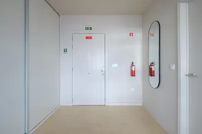 a hallway with two white doors and a fire hydrant at Garajau House - Sunrise to Sunset Ocean View Villa in Caniço