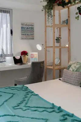 a room with a bed and a desk with a shelf at Funchal Sea View I by An Island Apart in Funchal