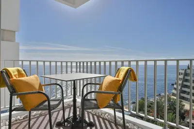 a table and chairs on a balcony overlooking the ocean at Funchal Sea View I by An Island Apart in Funchal