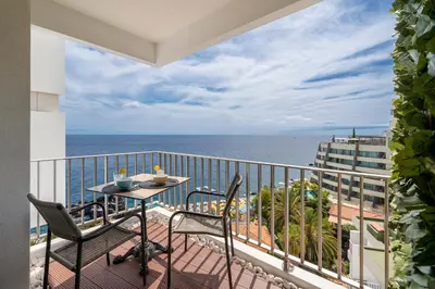 a balcony with a table and chairs and the ocean at Funchal Sea View I by An Island Apart in Funchal