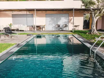 a swimming pool with blue water in front of a house at Casa Atlantico Suite in Ribeira Brava