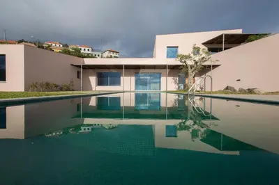 a swimming pool in front of a house at Casa Atlantico Suite in Ribeira Brava