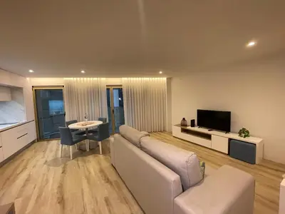 a living room with a couch and a tv and a table at Hortas Residence 13 in Funchal