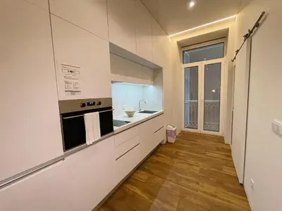 a kitchen with white walls and wooden floors at Hortas Residence 13 in Funchal