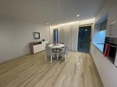 a living room with a table and chairs and a kitchen at Hortas Residence 13 in Funchal