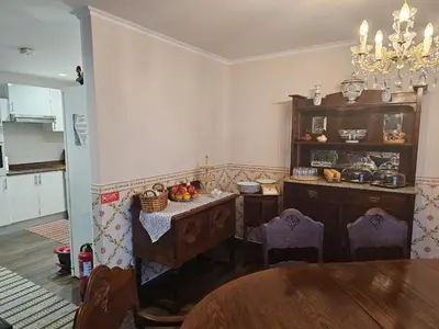 a kitchen with a table and a dining room at Casa Das Videiras in Seixal