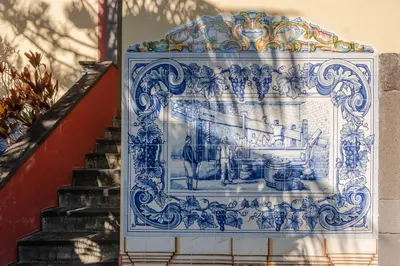 a blue and white picture on a wall next to a staircase at Casa Das Videiras in Seixal