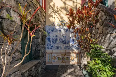 a stone wall with a blue and white tile fountain at Casa Das Videiras in Seixal